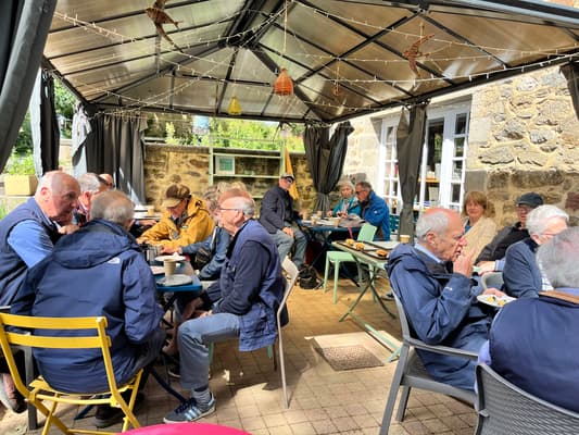 Renault Frères club members seated together enjoying lunch under a terrace canopy at Restaurant L'Épicure