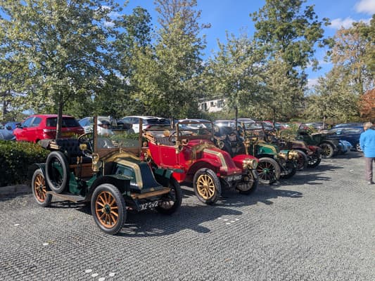 Line-up of pre-war Renault vintage cars including green tourer XZ 292 and red tourer BH 2465 on gravel at Woodland Manor Hotel