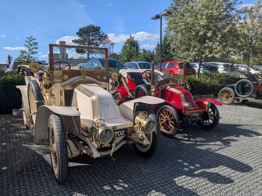 Cream 1905 Renault (registration 702) and red veteran Renault (registration C 6963) parked in the sunshine at Woodland Manor Hotel